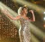 Photo of young adult woman singing on stage in long gold dress 